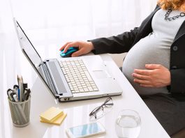 Eine schwangere Frau erledigt einen Job am Schreibtisch