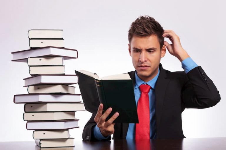 Mann schaut in ein Buch und ist verwirrt.