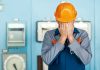 Ein Mann in Arbeitskleidung schlägt die Hände vors Gesicht aufgrund einer verhaltensbedingten Kündigung