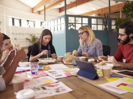 Mitarbeiter essen zusammen beim Frühstück - ein typisches Benefit Zu den typischen Mitarbeiter-Benefits gehört ein gemeinsames Essen