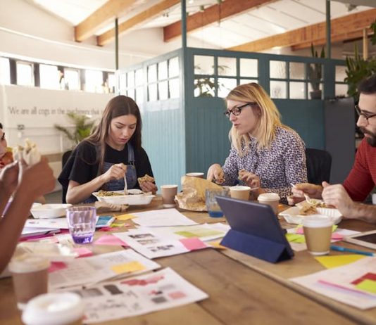 Mitarbeiter essen zusammen beim Frühstück - ein typisches Benefit Zu den typischen Mitarbeiter-Benefits gehört ein gemeinsames Essen
