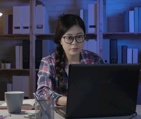 Eine Ghostwriterin sitzt am Laptop und schreibt die Bewerbung für jemand anderes