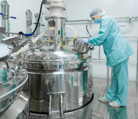 Ein Mensch in einer Chemiefabrik trägt Arbeitskleidung