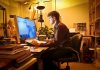Ein Mann sitzt im Home-Office am PC und arbeitet aufgrund der Vertrauensarbeitszeit in der Nacht
