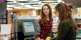Eine Schülerin arbeitet in ihrem Minijob an der Kasse eines Supermarktes und bekommt Mindestlohn
