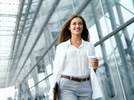 Eine Frau kehrt bei der Wiedereingliederung in den Job zurück und geht am Büro entlang