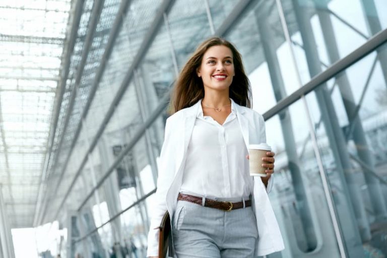 Eine Frau kehrt bei der Wiedereingliederung in den Job zurück und geht am Büro entlang