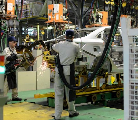 Männer als Zeitarbeiter in einer Autofabrik