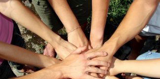 Aufeinander gelegte Hände sind ein Symbol für Teamwork