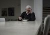 Ein Mann leidet am Empty-Desk-Syndrom und sitzt alleine Zuhause am Tisch und ist traurig