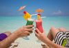 Zwei Menschen haben Erholungsurlaub und trinken Cocktails am Strand