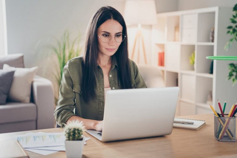 Eine Frau sitzt vor dem Laptop, sie ist auf Jobsuche.