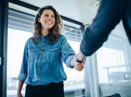 Eine Frau ist bei einem Jobinterview und begrüßt den Personaler