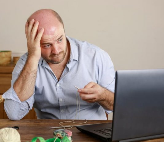 Ein Mann sitzt besorgt vor dem Laptop, er hat Bewerbungsangst