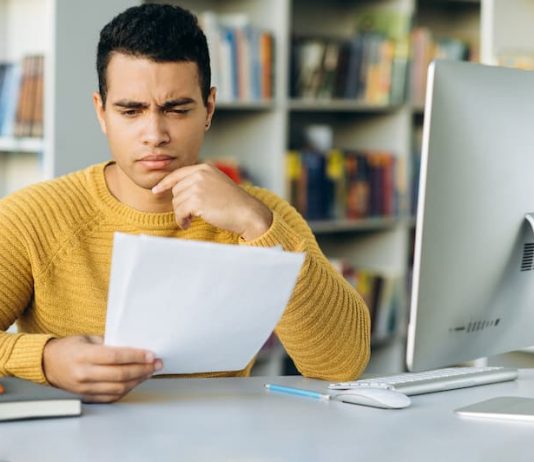 Ein Mann prüft die Ausschluss- und Verfallsfristen im Arbeitsvertrag