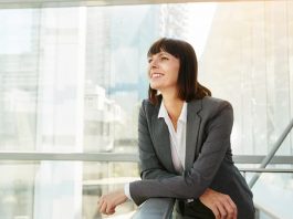 Ein Frau im Anzug steht an einer Balustrade, sie ist ein Beispiel für Female Leadership