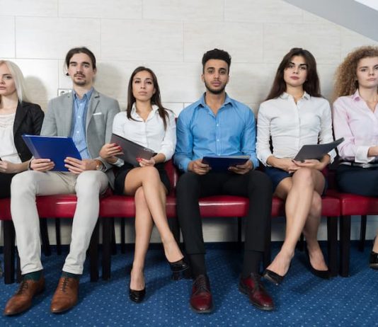 Eine Gruppe Bewerber sitzt in einer Reihe, 10 Tipps für das Vorstellungsgespräch