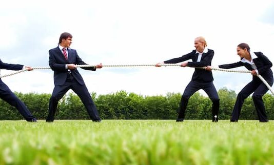 Eine Gruppe Menschen beim Tauziehen, ein Symbolbild für den Arbeitnehmermarkt und Arbeitgebermarkt