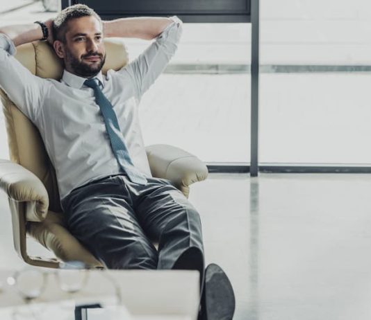 Ein Mann sitzt entspannt im Büro, sollte er die Komfortzone verlassen?