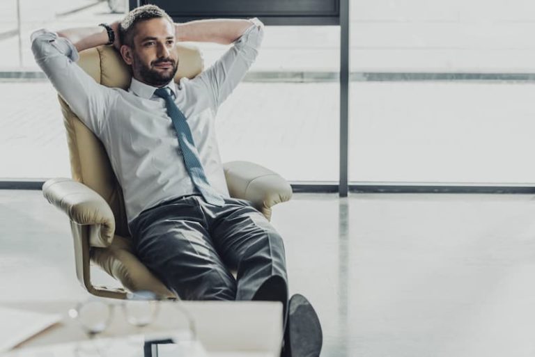 Ein Mann sitzt entspannt im Büro, sollte er die Komfortzone verlassen?