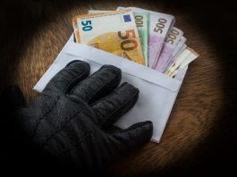 Geld in einem Umschlag wird über einen Tisch geschoben, was passiert bei Bestechlichkeit?