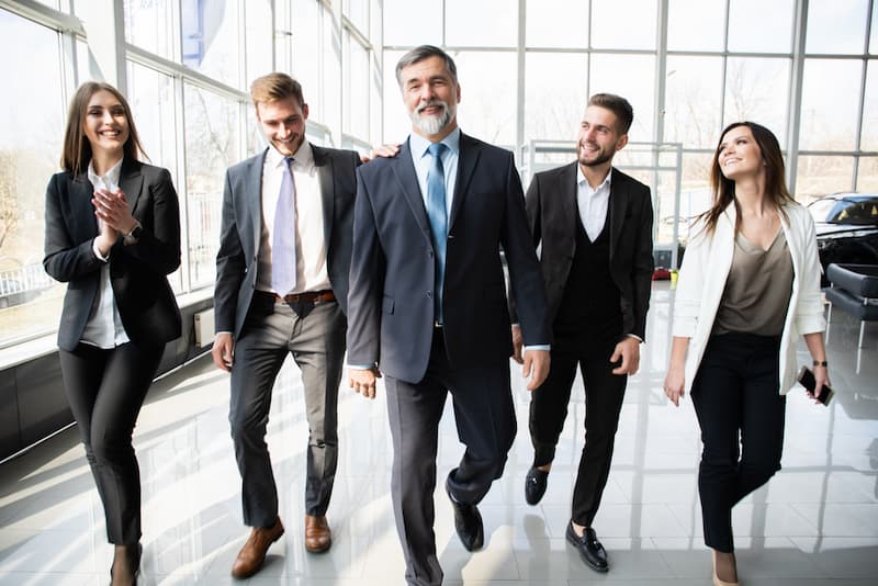 Ein Chef mit einer Gruppe Angestellter im Büro, was bedeutet Loyalität und Loyalitätspflicht im Berufsleben?