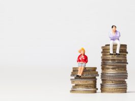 Ein Mann und eine Frau stehen auf Münzen, was ist der Gender Pay Gap?