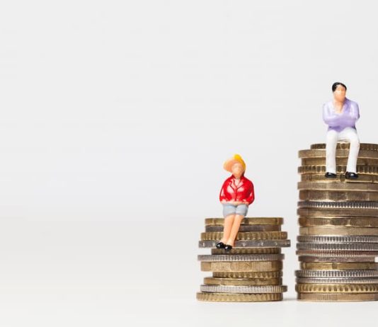 Ein Mann und eine Frau stehen auf Münzen, was ist der Gender Pay Gap?