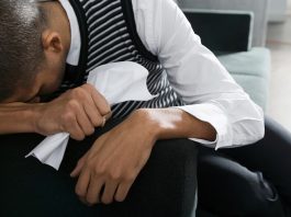 Ein Mann weint im Büro, was ist Diskriminierung am Arbeitsplatz?