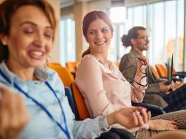 Mehrere Mitarbeiter lächeln, wie schafft man eine gute Arbeitsatmosphäre?