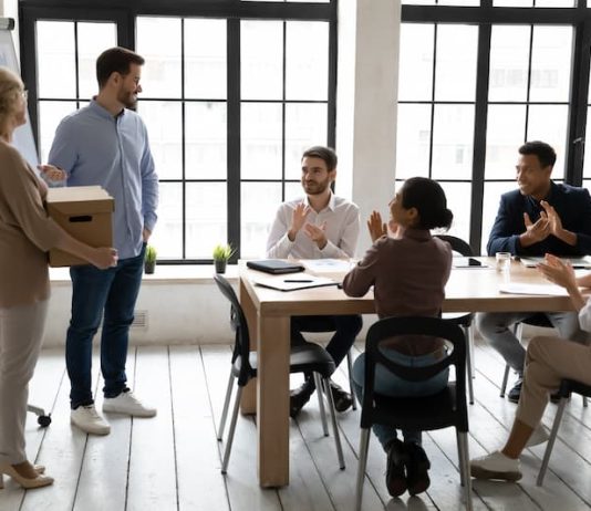 Ein Mitarbeiter hält eine Abschiedsrede zum Ruhestand einer Kollegin