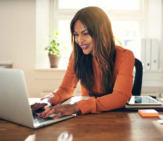 Eine junge Frau arbeitet am Laptop, sie ist ein Freelancer