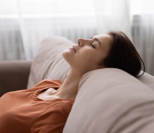 Eine Frau liegt entspannt auf dem Sofa, wie erhält man Selbstkontrolle?