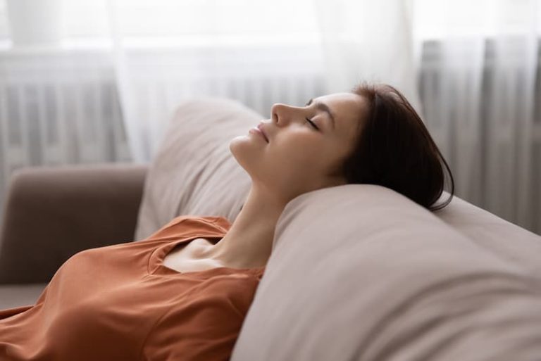 Eine Frau liegt entspannt auf dem Sofa, wie erhält man Selbstkontrolle?