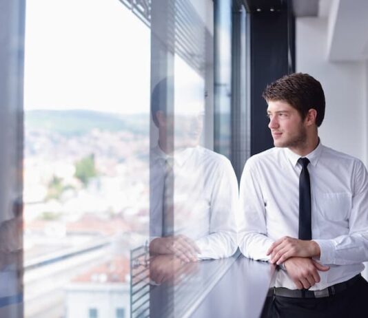 Ein Mann steht am Fenster, er möchte zurück zum alten Arbeitgeber