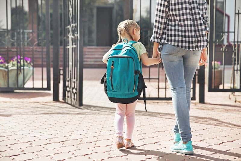 Eine Frau bringt ihr Kind zur Schule, dies ist möglich dank Teilzeit