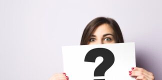 Eine Frau hält ein Schild mit einem Fragezeichen, was ist eine Identitätskrise?