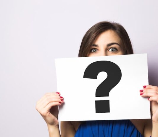 Eine Frau hält ein Schild mit einem Fragezeichen, was ist eine Identitätskrise?