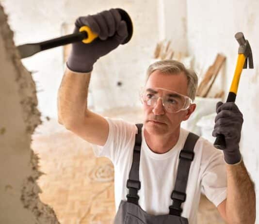 Ein älterer Mann zerlegt eine Mauer, wann kommt die Rente mit 70?