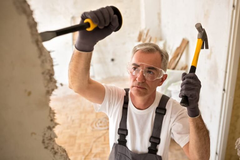 Ein älterer Mann zerlegt eine Mauer, wann kommt die Rente mit 70?