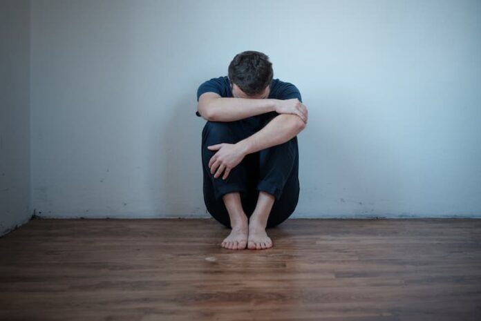 Ein Mann sitzt auf dem Boden, was kann man tun, wenn man psychisch arbeitsunfähig ist?