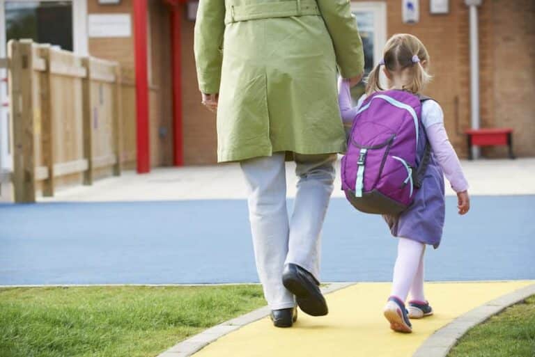 Eine Mutter bringt das Kind in den Kindergarten, was ist betriebliche Kinderbetreuung?