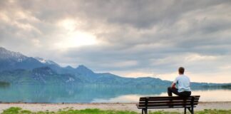 Ein Mann sitzt am See und denkt nach, was sind Jobs mit Sinn?