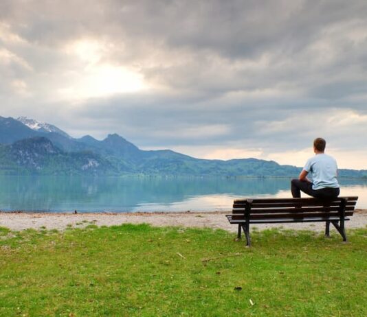 Ein Mann sitzt am See und denkt nach, was sind Jobs mit Sinn?