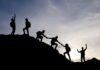 Mehrere Menschen helfen sich beim Bergaufstieg, was ist Gruppendynamik?