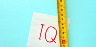 Ein Maßband neben einem Papier auf dem IQ steht, wie lässt sich der Intelligenzquotient messen?