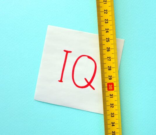 Ein Maßband neben einem Papier auf dem IQ steht, wie lässt sich der Intelligenzquotient messen?