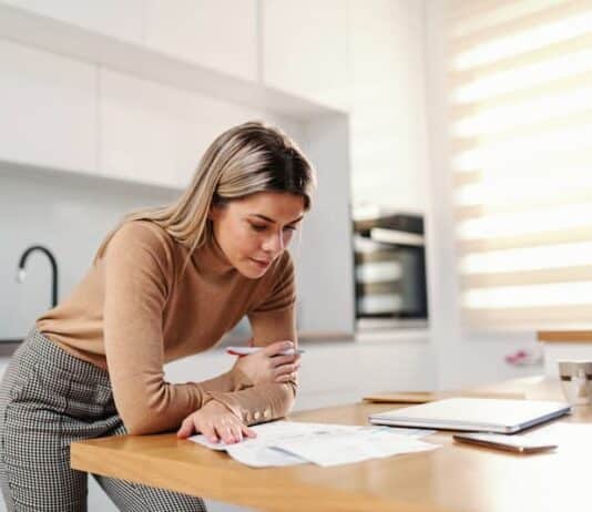 Eine Frau betrachtet ihre Unterlagen, sie möchte die Krankenkasse wechseln