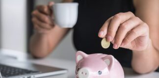 Ein Sparschwein wird befüllt, was sind gute Tipps zum Geld sparen?