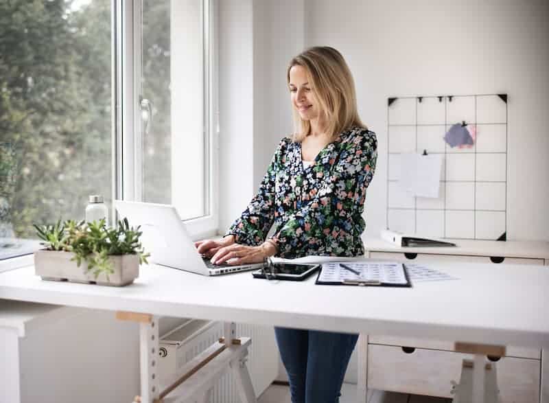 Eine Frau an einem Stehtisch, was ist Ergonomie am Arbeitsplatz?